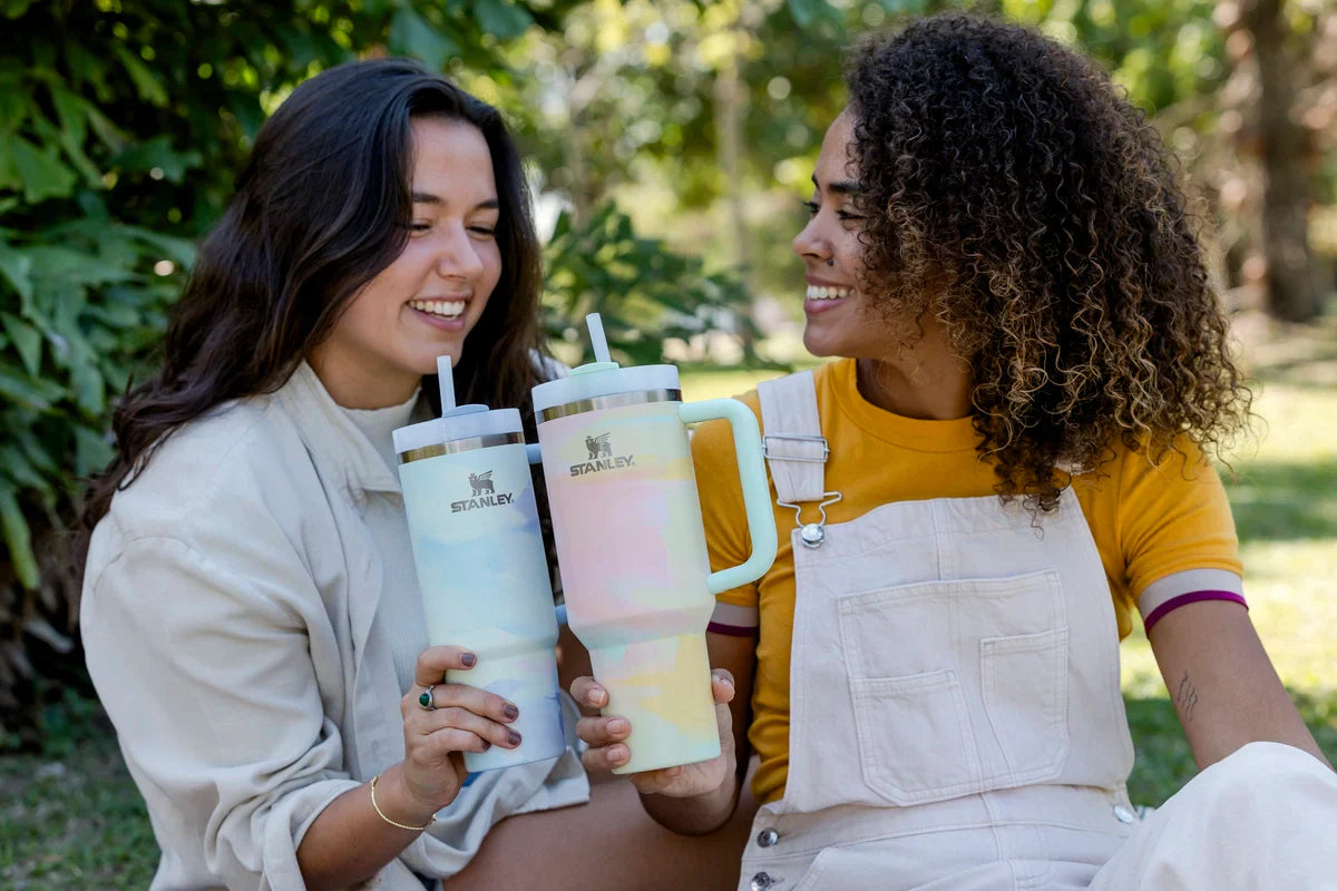 Duas amigas brindando com bebidas que elas gostam e estão na temperatura ideal para um momento de descontração.