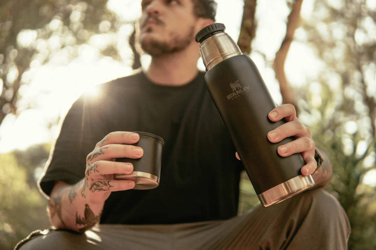 Um homem segurando a garrafa Adventure 2.0 da Stanley, aproveitando as dicas do guia Stanley para aventureiros