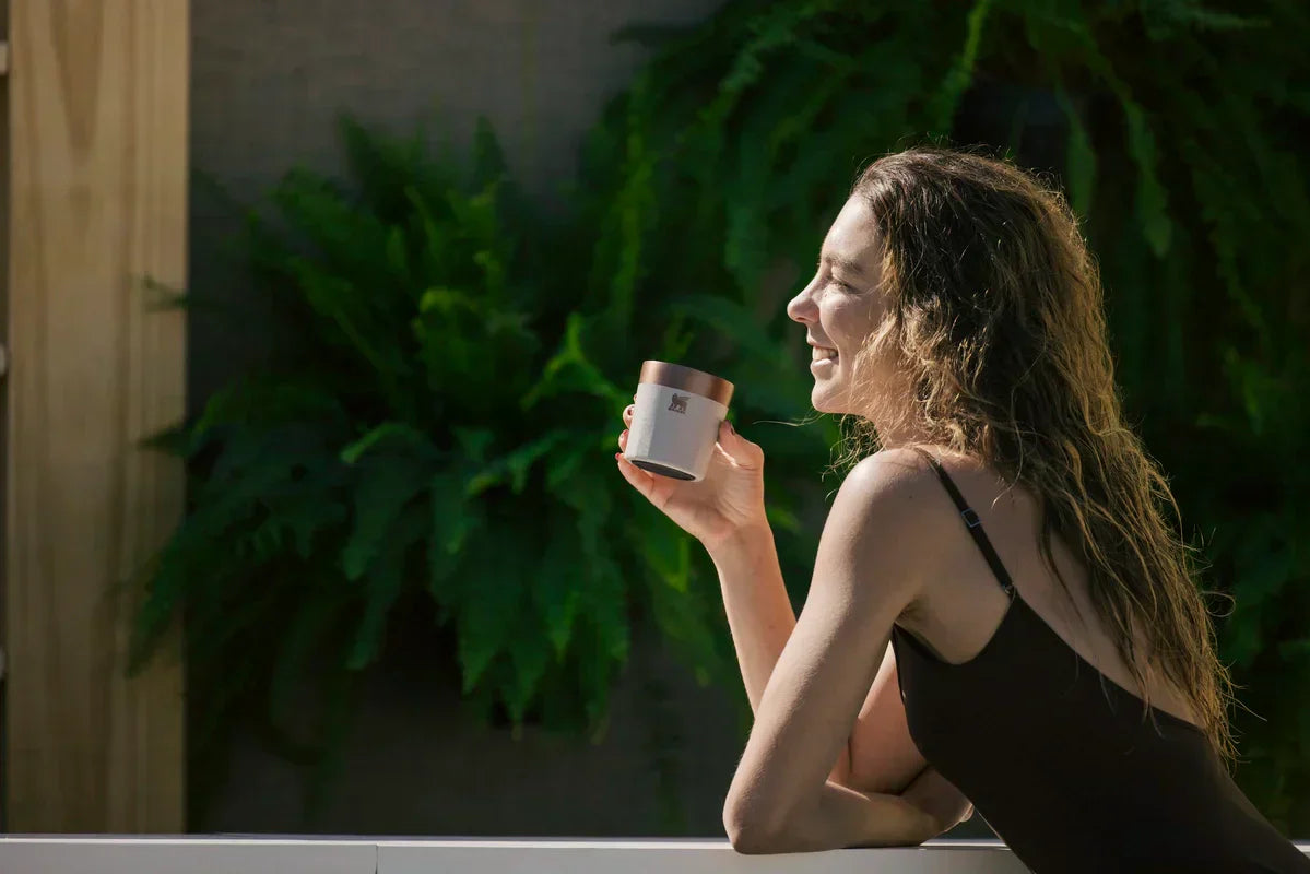 Uma mulher rindo tranquila depois de um ter falado “meu copo Stanley caiu no chão” e ter visto que ele não quebrou.